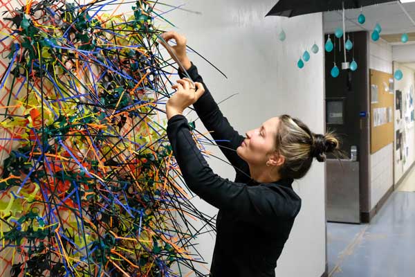 Student installs sculpture for display