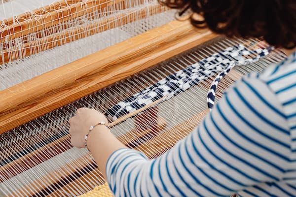 Student uses weaving loom