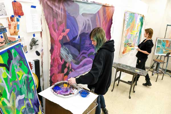 Female student works on large painting