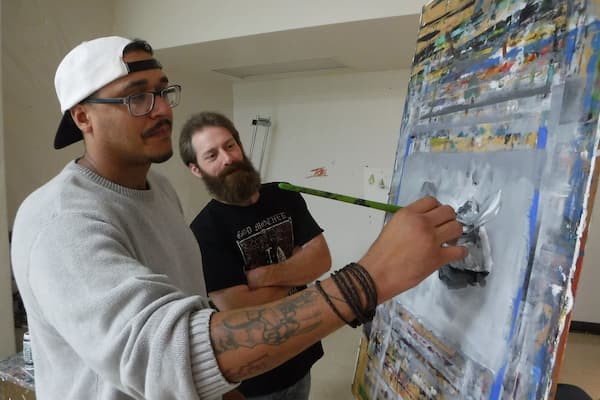Professor observes student painting