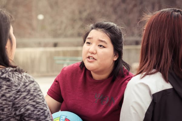 Three multicultural female students having a conversation