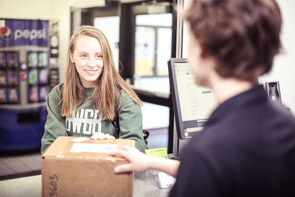 Woman picking up a mailed package from a residence life student employee