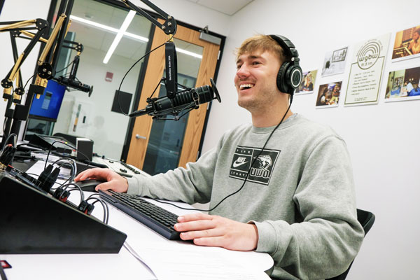 Communication student in recording podcast in studio