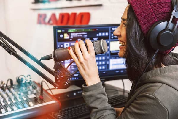 Female speaks into microphone in radio studio