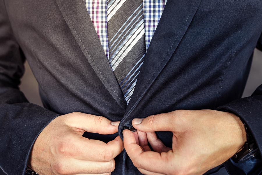 Buttoning a blazer over a button-down shirt and tie