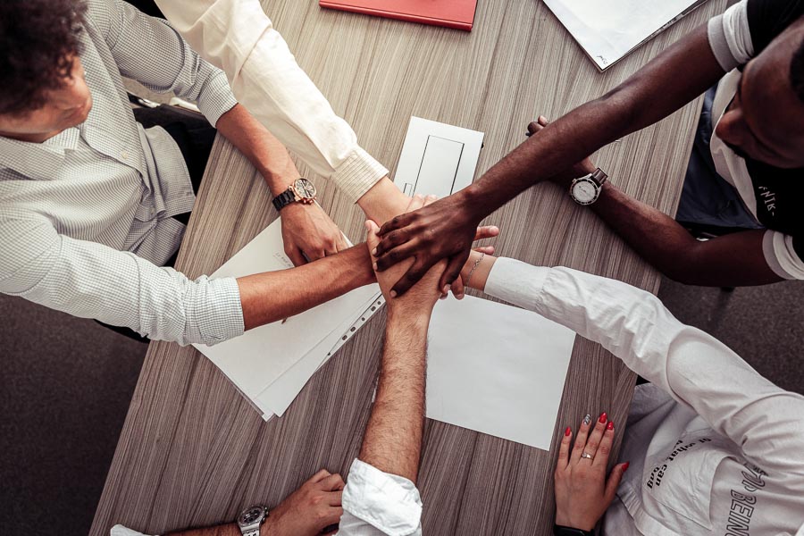 Employees put hands together showing teamwork