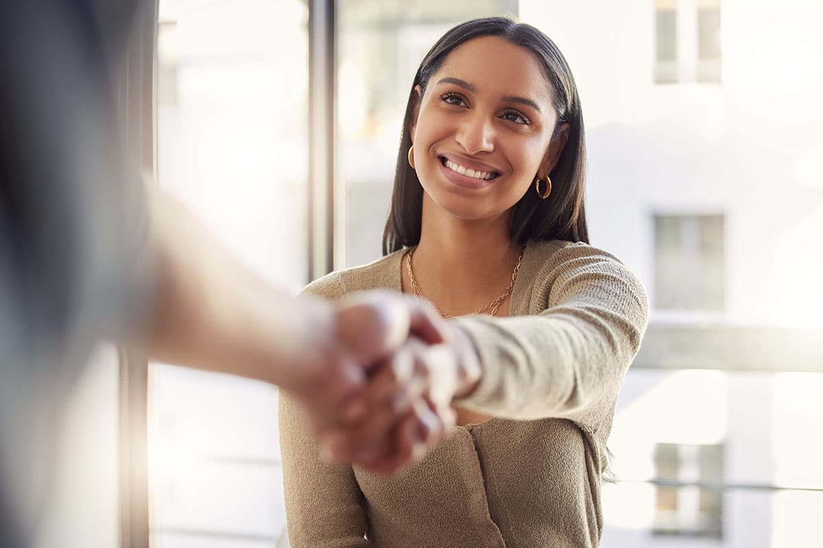 Woman shaking hands with a person off camera