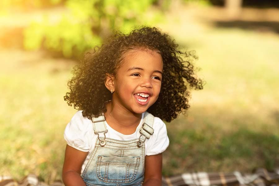 Young child laughing outside on lawn