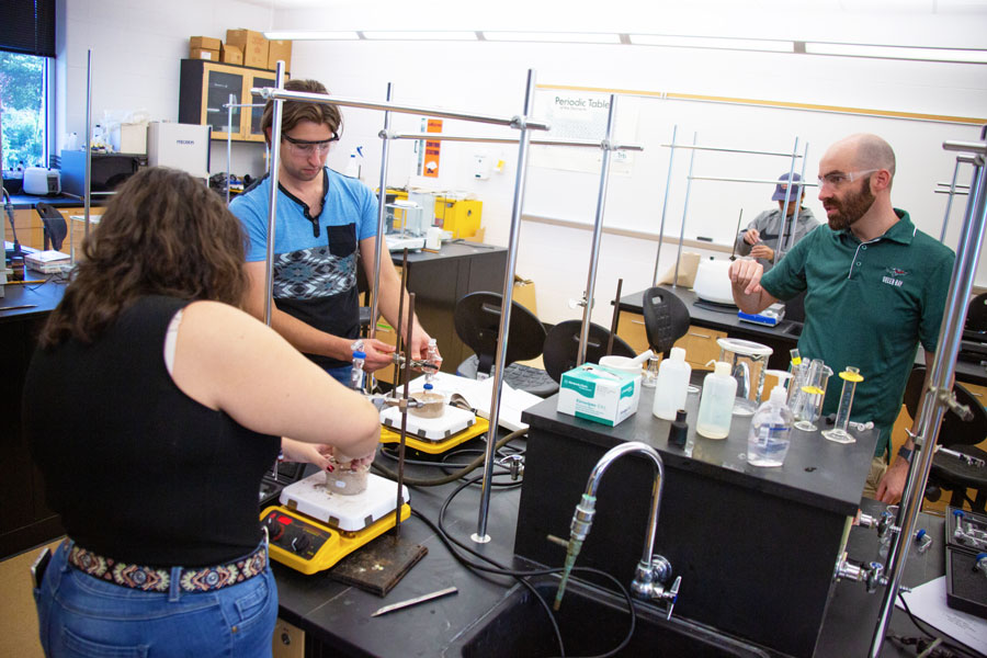 Chemistry students in lab working with professor