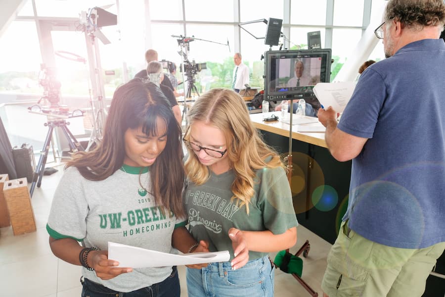 Two students look over script for RISE campaign