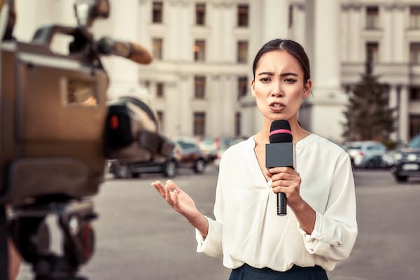 Female reporter speaks to camera crew