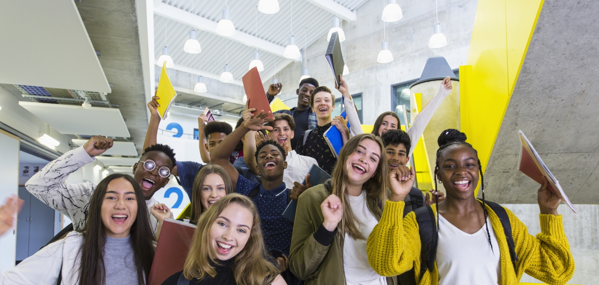 Teenagers holding papers and smiling