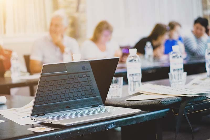 partially closed laptop on a table during a training session