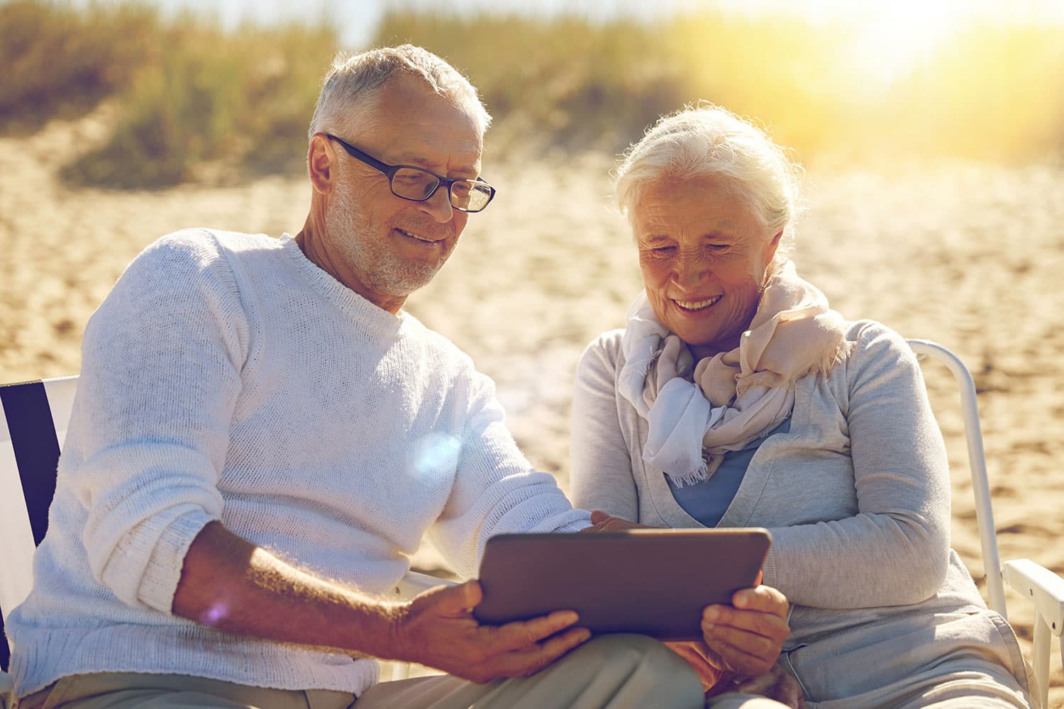 Mature adults outside watching a virtual class on their tablet