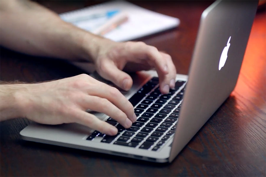 Hands typing at computer