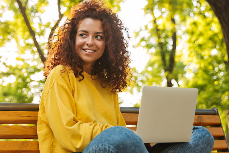 girl on bench with laptop