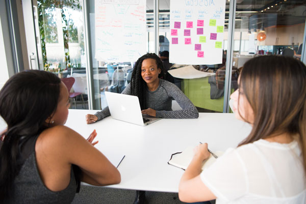 Three females discuss data during meeting