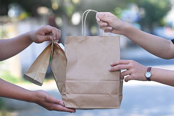 Bags being given to a student who ordered food delivery.