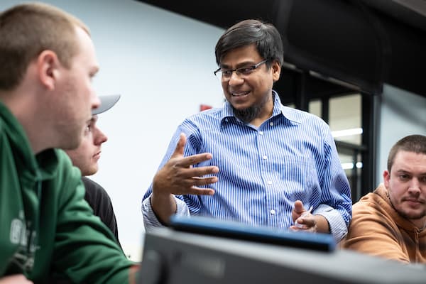 Faculty member Maruf speaking with students