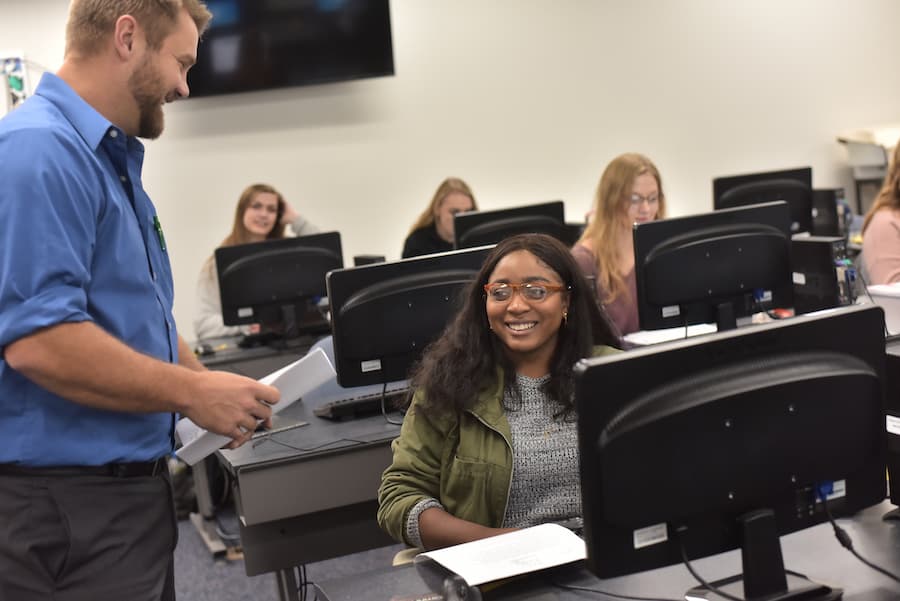 Professor and student in writing lab smiling