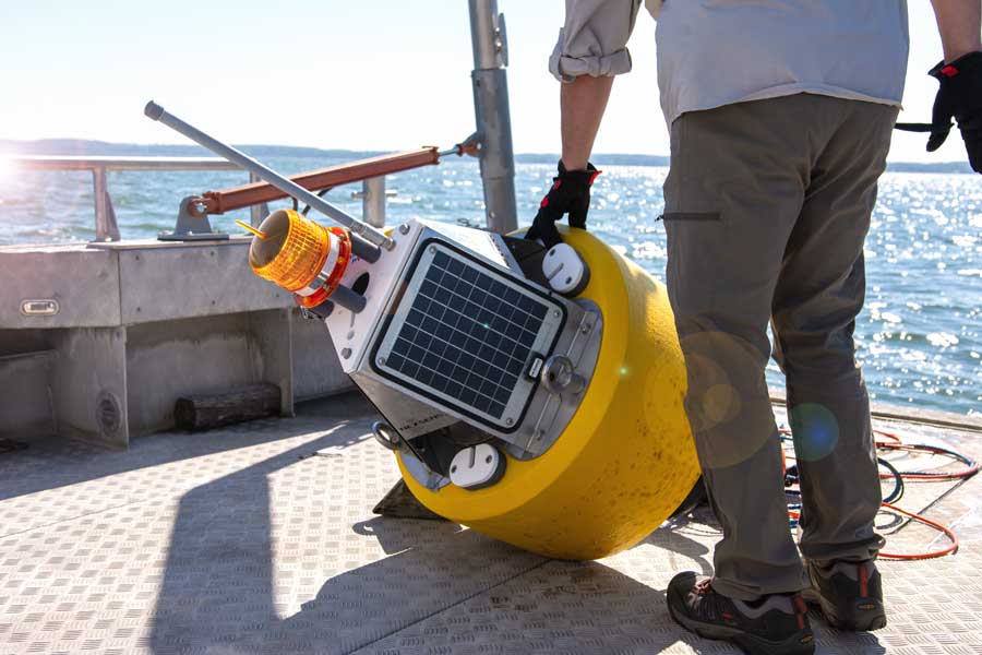UW-Green Bay researchers check a buoy armed with wireless high-tech sensors in the Bay of Green Bay
