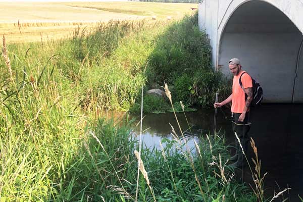 Student studys water under bridge