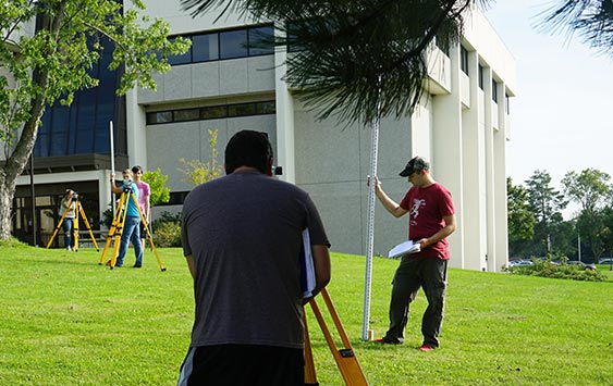 Students doing surveying work on the Lab Sciences building lawn