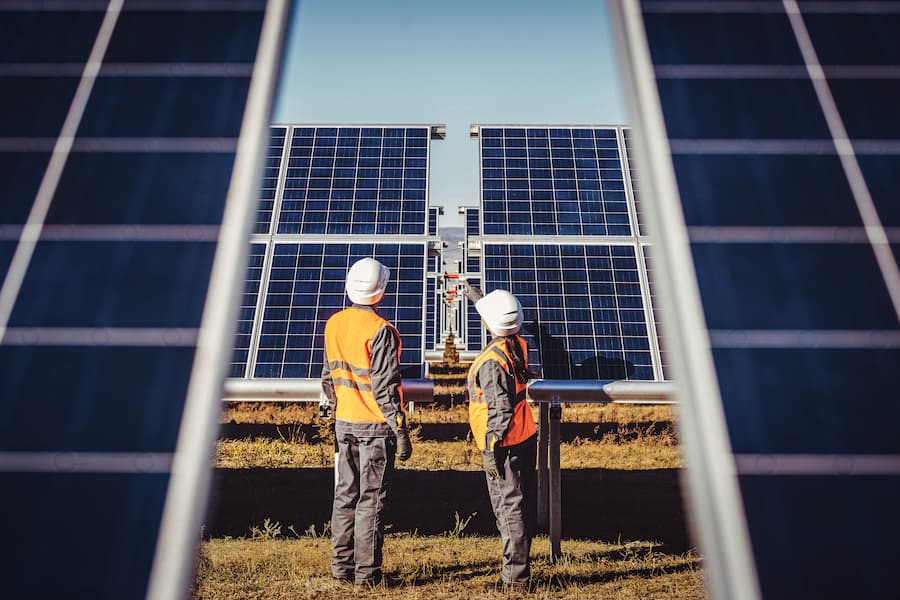 Two environmental planning professionals work with solar panels