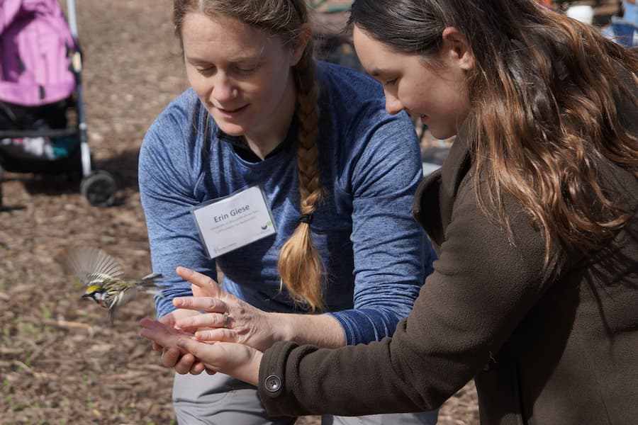 Student and professor release bird at bird banding