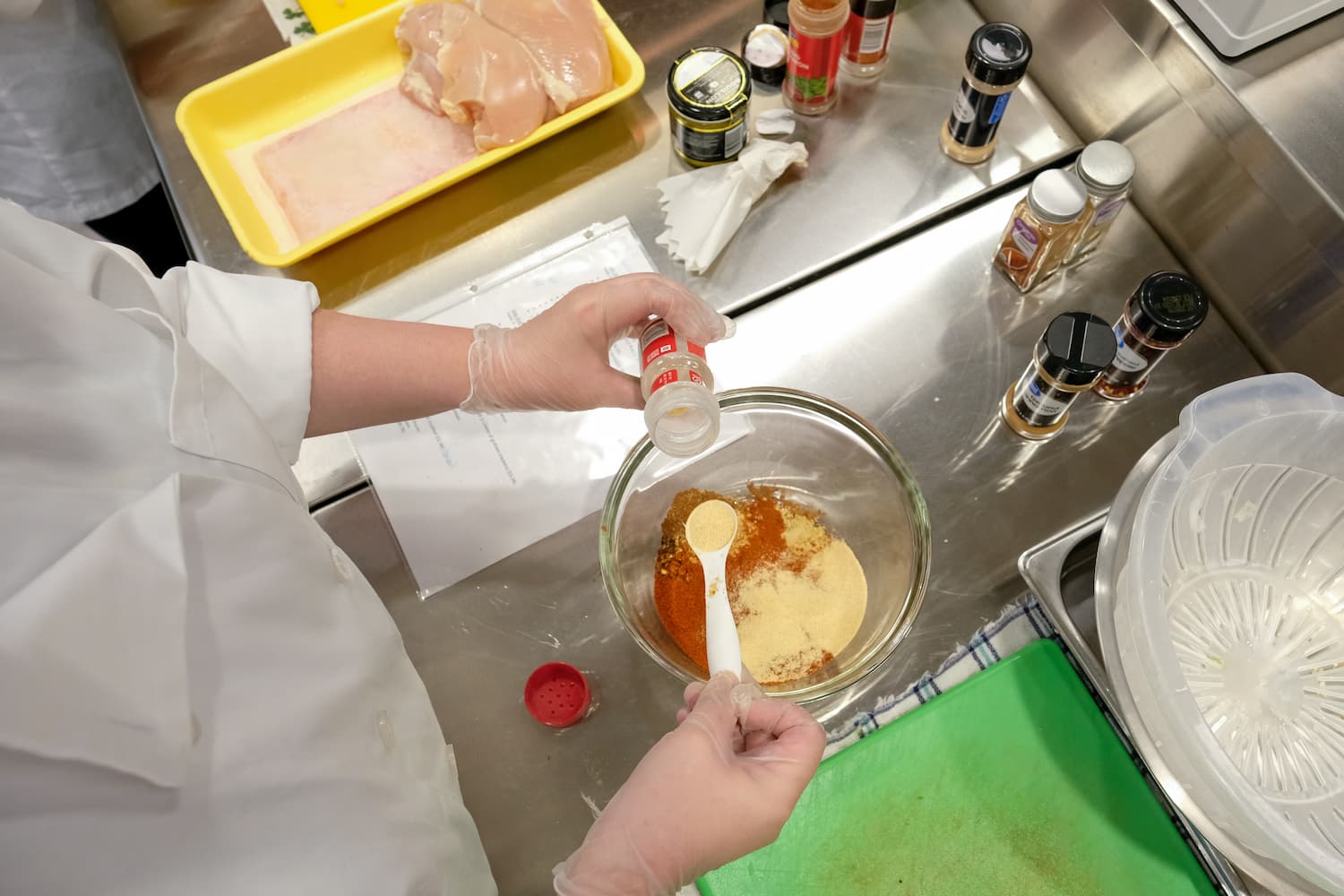person mixing ingredients at food lab