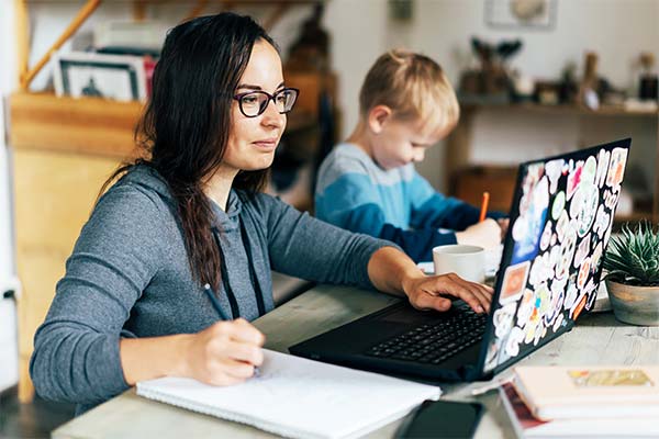 Student takes classes from home with her child playing next to her