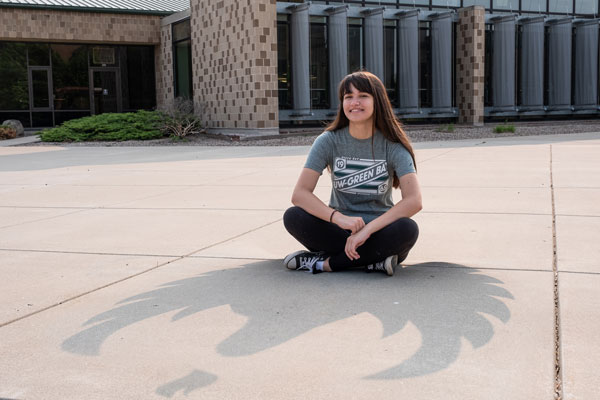 UWGB student sitting outside with Phoenix shadow