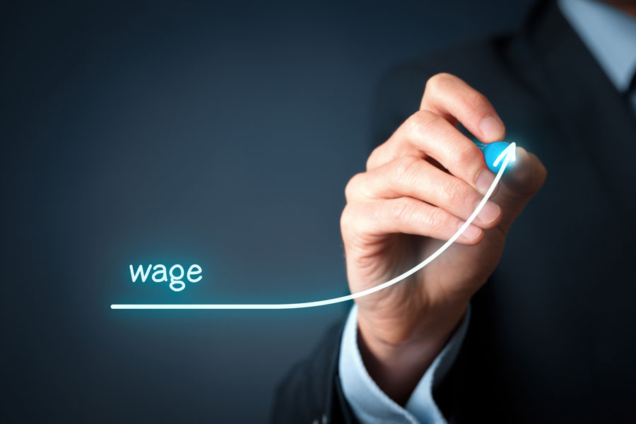 Man in suit drawing upward arrow showing wage increase