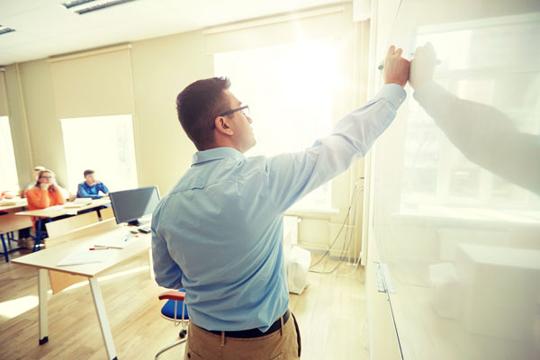 Professor writing on white board