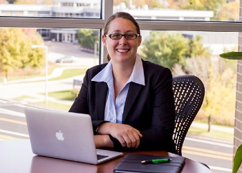 Person in a blazer with a laptop