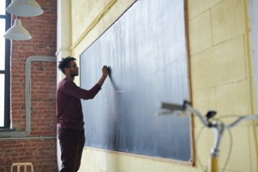 Person writing on a chalk board