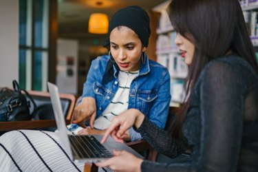 Two female students working on a laptop