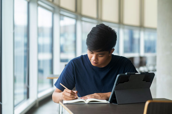 Asian student sits at desk studying