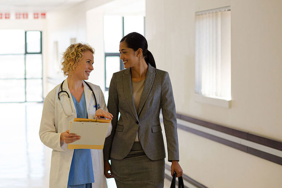 Female Health management worker speads with female doctor