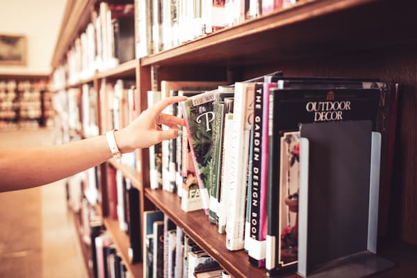 hand selecting a book from the library