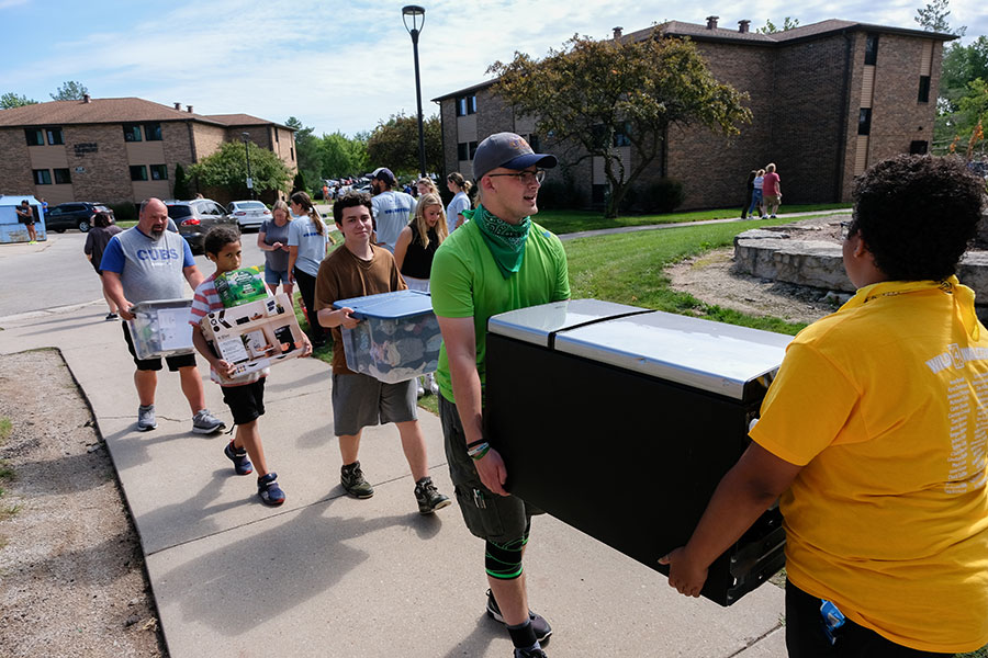 Students and guests carrying bins at UWGB move-in