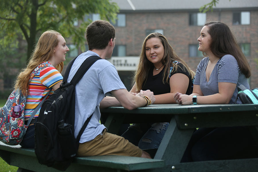 student sitting outside of housing in summer