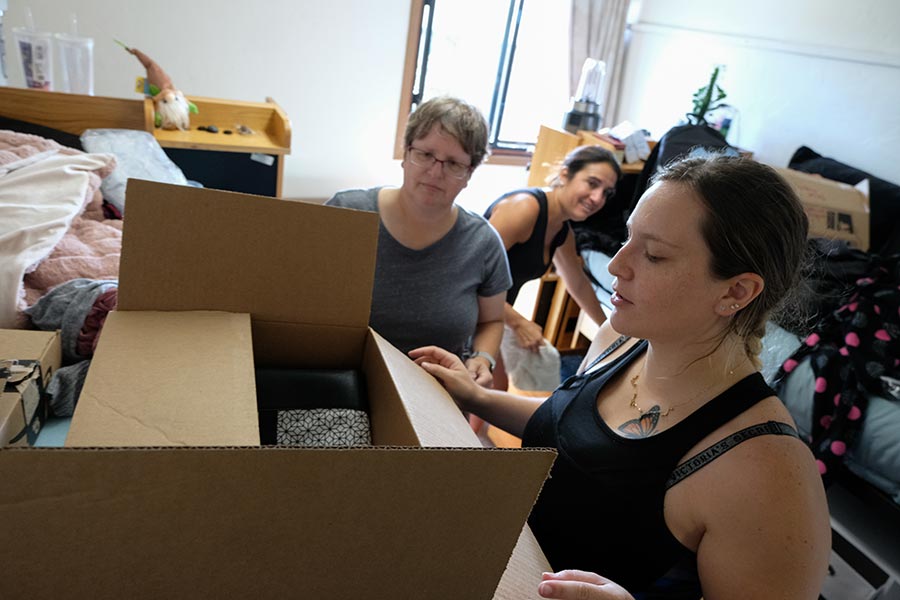 Student unpacking boxes in her new dorm room