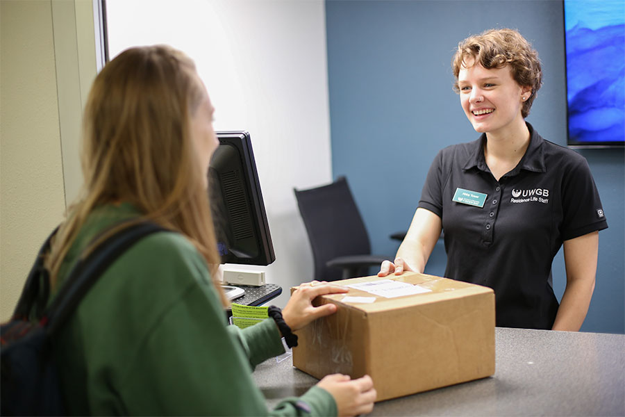 Student picking up a package from the mailroom counter