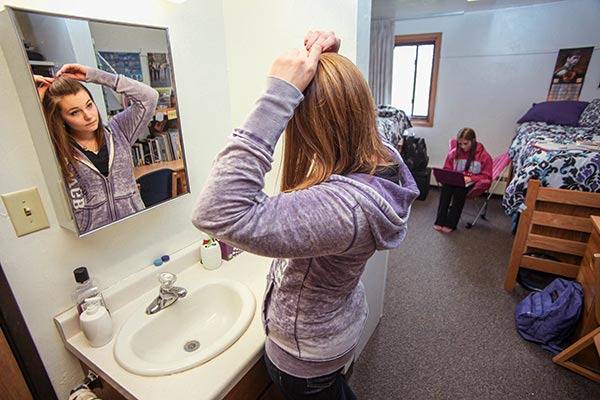 UWGB student fixing her hair at her private vanity in her dorm room