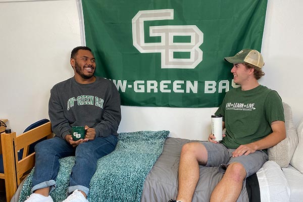 guy roommates seated on a bed in a UWGB dorm