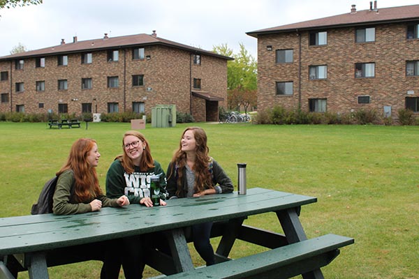 UWGB students at a picnic table near the dorms