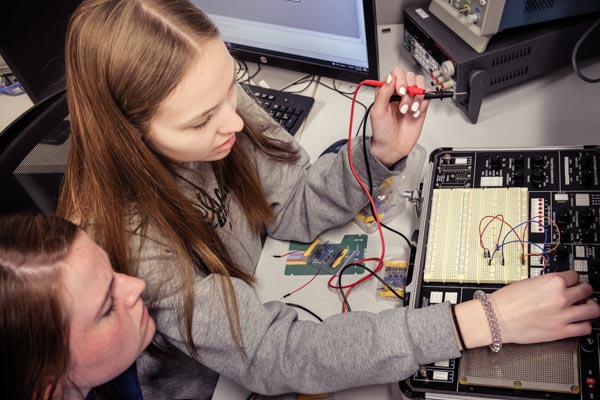 Young women doing coursework in the electrical engineering lab