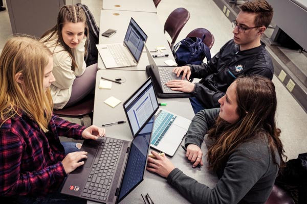 Students doing group work, each with a laptop