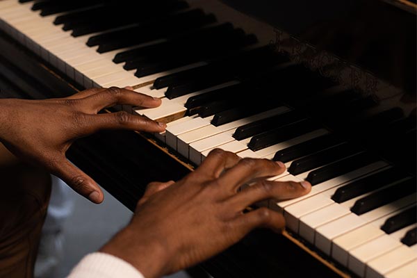 Student playing piano accompaniment at a music performance